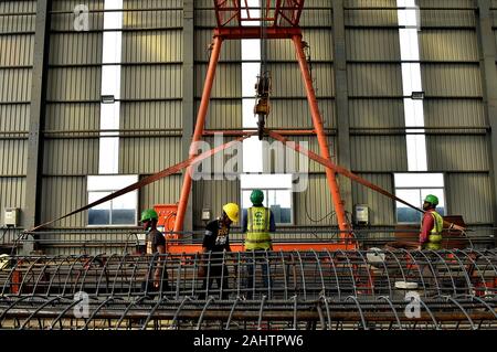 (200101) -- DHAKA, Jan. 1, 2020 (Xinhua) -- Laborers work in the plant where the box girders of elevated railway of Padma Bridge Rail Link Project are manufactured at Keraniganj on the outskirts of capital Dhaka, Bangladesh, Dec. 31, 2019. About two months into the commencement of a project linking capital Dhaka's central Kamalapur railway station with a western Bangladesh district, the Chinese engineers on Tuesday successfully installed the first box girder of the country's longest elevated railway. The 17-km elevated railway is a part of China-financed Padma Bridge Rail Link Project which Ba Stock Photo