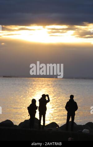 Tokyo, Japan. 1st Jan, 2020. People watch the sunrise which appears behind the clouds on the New Year's Day at a beach in Tokyo on Wednesday, January 1, 2020. Millions of Japanese people visit shrines and temples to celebrate the New Year. Credit: Yoshio Tsunoda/AFLO/Alamy Live News Stock Photo