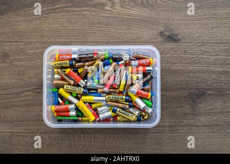 Adelaide, Australia - July 7, 2019: Assortment of used household AA and AAA batteries collected in plastic container ready for recycling. Illustrative Stock Photo