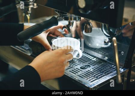 Barista making coffee in a coffee machine Stock Photo