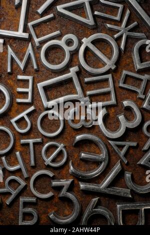 Backgrounds and textures: assorted metal cyrillic letters on a rusty background, typographic art abstract Stock Photo
