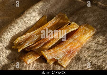 Six dried beef tendons on burlap. Natural chewing treats for dogs. Dental treats for pets of all breeds and ages. Selective focus. Close up Stock Photo Alamy