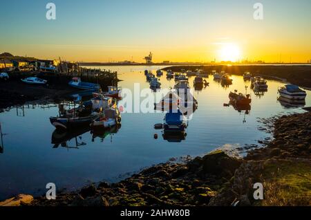 Fishing and pleasure boats in Paddys Hole Harbour, Teesmouth, Redcar Cleveland UK at sunset on a sunny winter afternoon Stock Photo