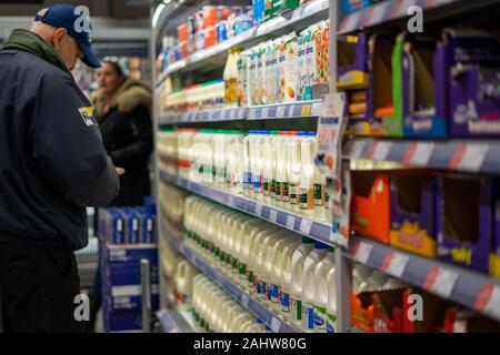 A middle aged male in a supermarket shopping for milk or buying milk Stock Photo