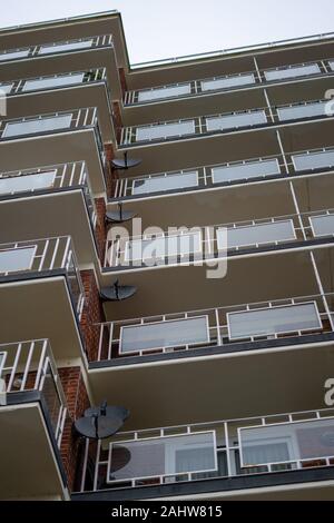 A block of flats or an apartment block with balconies and a satellite dish on the exterior of every flat Stock Photo