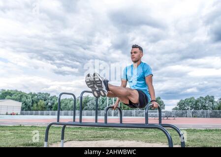 Young sportsman, male athlete, exercise in abdominal muscles, twisting abdominal training, summer, workout fitness, active lifestyle, sportswear Stock Photo