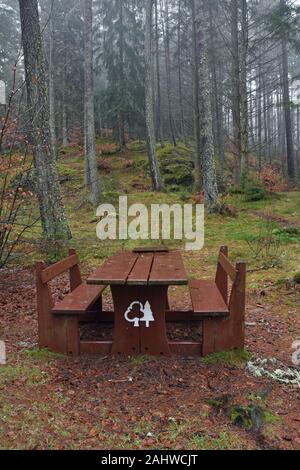 Picnic bench and table in forest. Taken on wet winter day in Faskally Woods, Loch Dunmore near Pitlochry, Perthshire, Scottish Highlands, UK Stock Photo