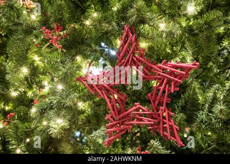 Christmas decorations hanging on a large Christmas tree. Stock Photo