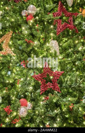 Christmas decorations hanging on a large Christmas tree. Stock Photo