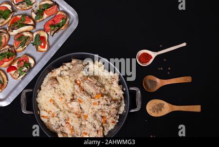 Top view of Indian traditional dishes and appetizers: chicken curry, pilaf, naan bread, samosas, paneer, chutney on rustic background. Table with choi Stock Photo