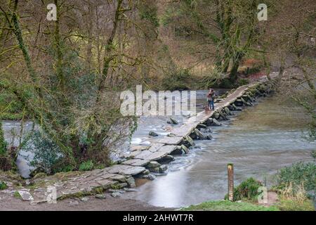 The Tarr Steps is a clapper bridge which spans the River Barle in the Exmoor National Park, Somerset, England. Stock Photo