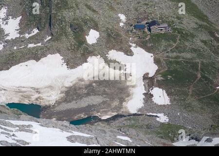 High altitude mountain landscape with hut and small glacier lakes in the Alps Stock Photo