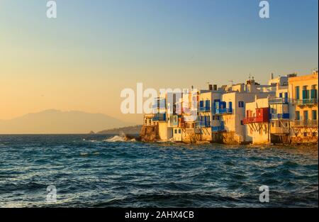 Sunset view of the famous pictorial Little Venice in Mykonos island. Splashing waves over bars and restaurants of Mykonos old town, Cyclades, Greece. Stock Photo