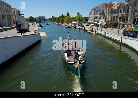 Tourists enjoy a boat trip on a traditional Moliceiro canal boat on the central canal in Aveiro Portugal Stock Photo