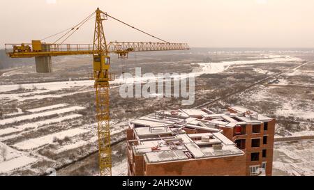 Snowy construction site and crane. Drone view. Stock Photo