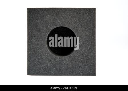 Technical Round Sponge. Black sponge foam in a shape of electronic or computer part, a protective equipment on white background. Stock Photo