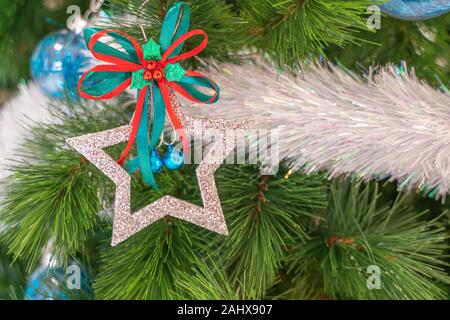 Beautiful Christmas star hanging from a decorated Christmas tree Stock Photo