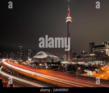 CN Tower, Toronto, Ontario by night with light trails showing Gardiner Expressway Stock Photo