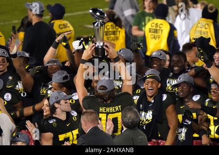 Pasadena, United States. 01st Jan, 2020. Oregon Ducks quarterback Justin Herbert holds up the Leishman Trophy to his teammates after defeating the Wisconsin Badgers at the 106th Rose Bowl in Pasadena, California Wednesday, January 1, 2020. The Ducks defeated the Badgers 28-27. Photo by Jon SooHoo/UPI . Credit: UPI/Alamy Live News Stock Photo