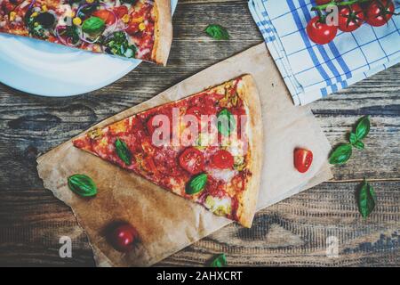 Traditional italian food pizza with mozzarella, tomato and salami on wood table Stock Photo