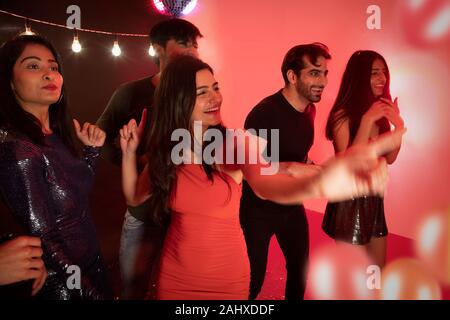 Group of friends dancing together on new year’s eve. Stock Photo
