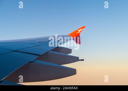 View of the starboard wing of a Qantas Airbus A380 airliner approaching Sydney Airport at sunrise, Australia Stock Photo