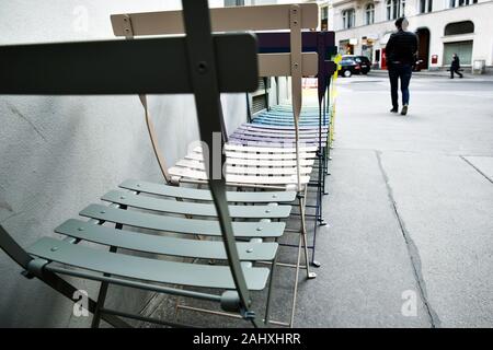 Multicolored chairs in a row on street. Stock Photo