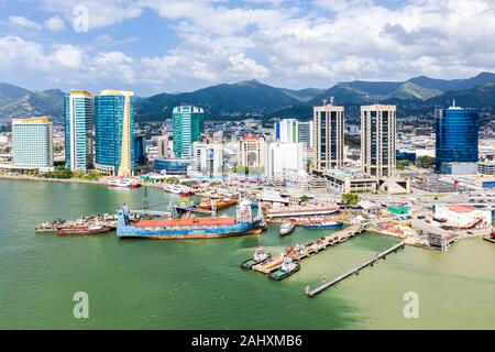 Port of Spain, Trinidad and Tobago - Dec 24 2019: Aerial view of the capital city of a tropical island. Skyscrapers of the downtown and a busy sea por Stock Photo