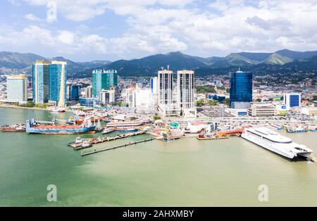 Port of Spain, Trinidad and Tobago - Dec 24 2019: Aerial view of the capital city of a tropical island. Skyscrapers of the downtown and a busy sea por Stock Photo