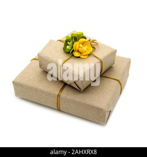 Two boxes packed in brown paper with yellow and green paper flowers. Stock Photo