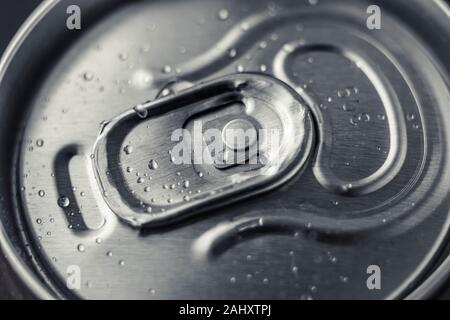 Closed metal can of cola on black background. Top view. Can drink with water drops. Steel shiny bottle of beer. Stock Photo