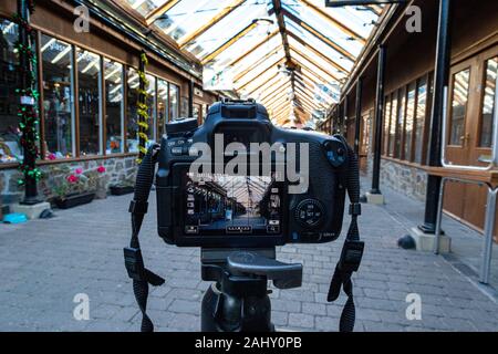 Camera on a Tripod With Viewfinder View and Subject of Great Torrington Pannier Market, Shops and Glass Roof Detail Looking Towards the Main Town. Stock Photo