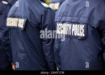 Security police officers in uniforms are seen from their backs. Stock Photo
