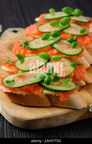 Sandwich with salmon on wooden plate Stock Photo