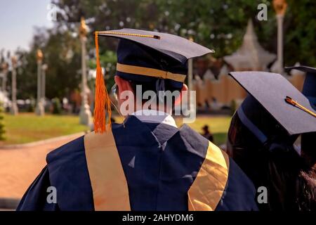 Students wearing caps & gowns are standing in a group after graduating from Mengly Kwock Education in Phnom Penh, Cambodia. Stock Photo