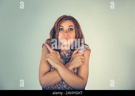 Portrait confused young woman pointing in two different directions not sure which way to go in life or what to do isolated on light green background. Stock Photo