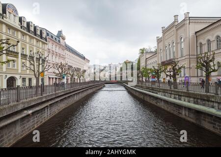 Karlovy Vary, Czech Republic - May 5, 2017: Tepla river perspective, ordinary people walk the street