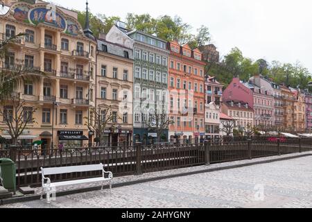 Karlovy Vary, Czech Republic - May 5, 2017: Colorful old houses along Tepla river coast. Ordinary people walk the street Stock Photo