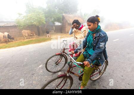Bangladesh â. “ January 06, 2014: On a foggy winter morning, two young girls are going to school by riding bicycle. at Ranisankail, Thakurgaon.