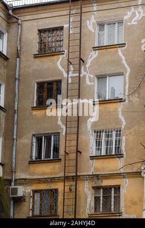 Facade of an old apartment building with repaired cracks. External repair of an old four-story building. Without people. Stock Photo