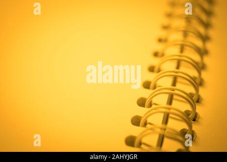 clean paper in spiral notebook, yellow light. Stock Photo