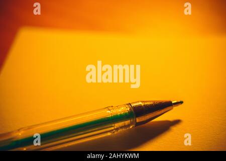 Gel pen on a notebook paper, accessory for creativity on the table. Stock Photo