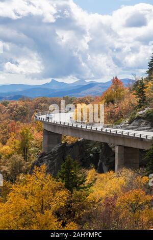 Car drives over Linn Cove Viaduct, Blue Ridge Parkway in the Fall, NC Stock Photo