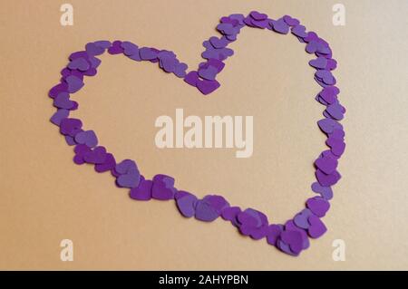 Composition of tiny purple hearts on yellow background for St. Valentines Day 2020. Holiday mood. Stock Photo