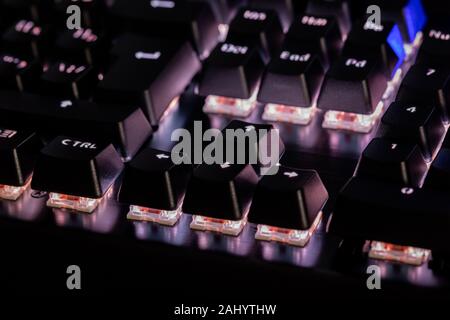 a close-up view of black mechanical pc keyboard with white backlight. Stock Photo