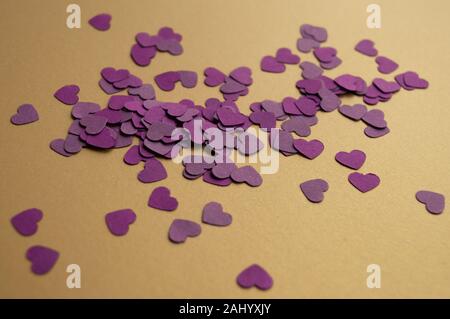 Composition of purple hearts on the golden background for St. Valentines Day 2020. Holiday mood. Stock Photo