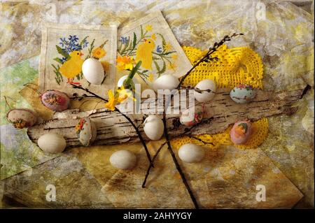 Easter eggs and Easter decorations spread out on grungy cloth.  Horizontal image with digital texture layer. Stock Photo