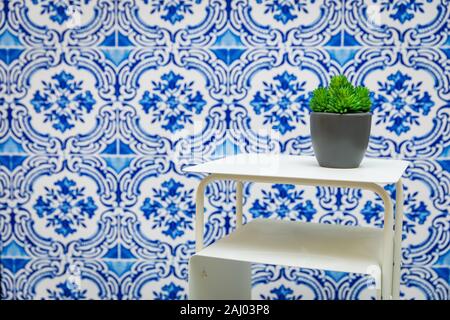 small white shelf with green plant on blue floral tiled wall background