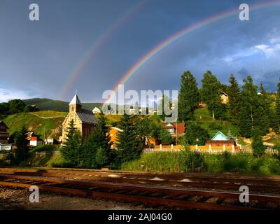 Twin rainbow over Carpathian mountain village. Picturesque and magic Carpathian Mountains in summer. Eastern Carpathians, Ukraine Stock Photo