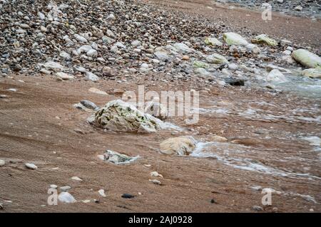 Foam on the beach from a receding wave at North Landing at Flamborough Head, Humberside Stock Photo